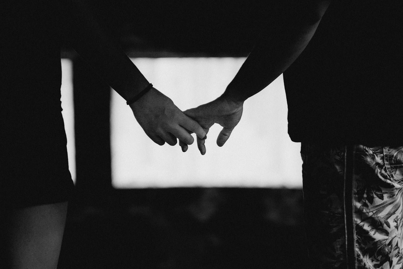 Two people hold hands, symbolizing connection.